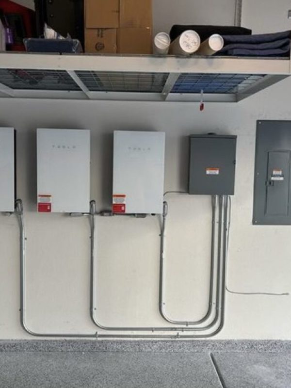 Garage wall with electrical panels and wiring.